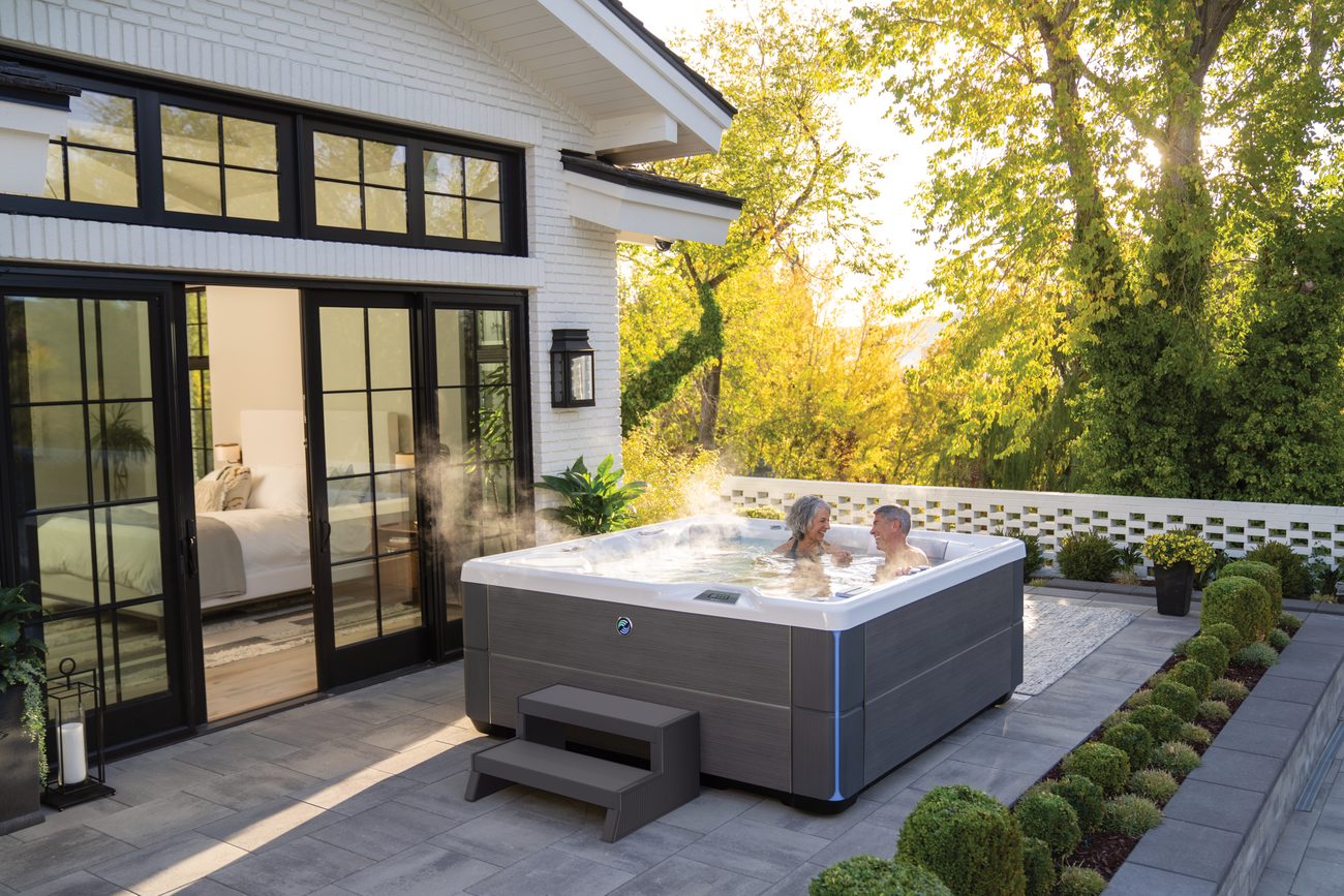 Hot Spring Highlife Aria hot tub in a landscaped backyard