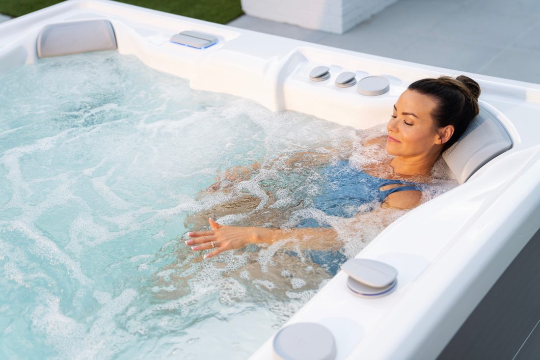 Woman relaxing in a Hot Spring Highlife hot tub at sunrise